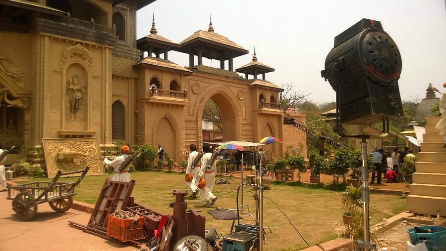 Tourists posing at a Bollywood film city gate